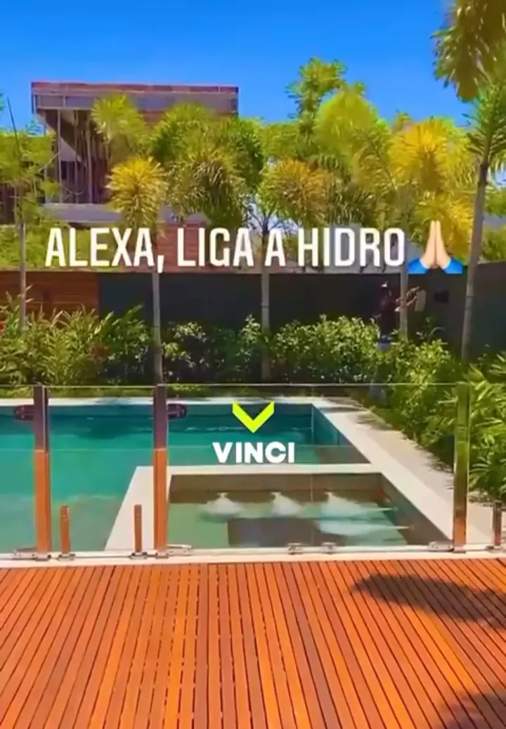 Piscina com hidromassagem ligada, deck de madeira e jardim tropical, com a frase do comando de voz que ligou a hidro.