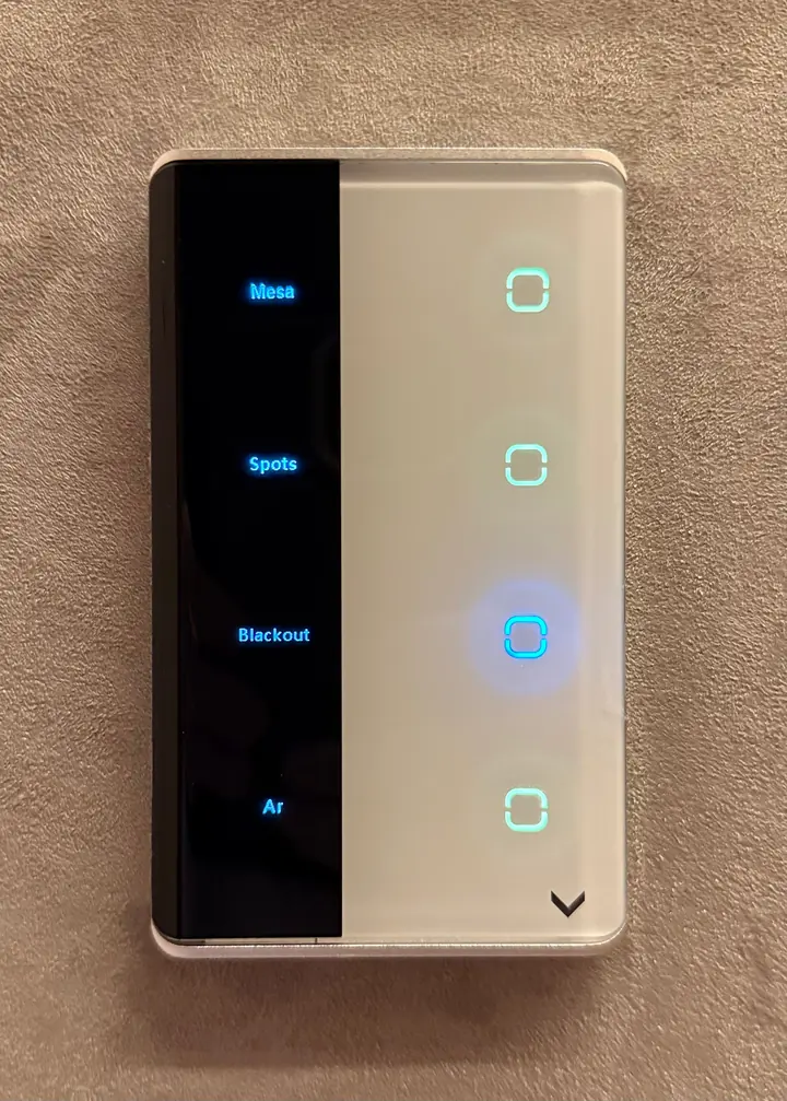 Interruptor touch de vidro branco com faixa preta e as legendas Mesa, Spots, Blackout e Ar.