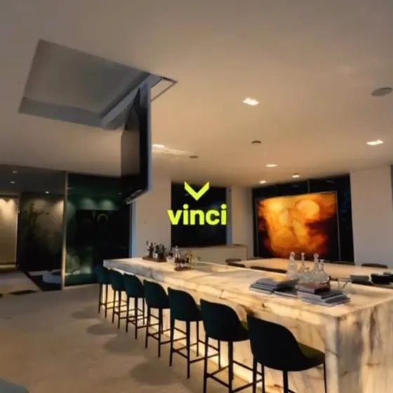 Bar com bancada de ônix iluminada e uma TV que desce do forro.